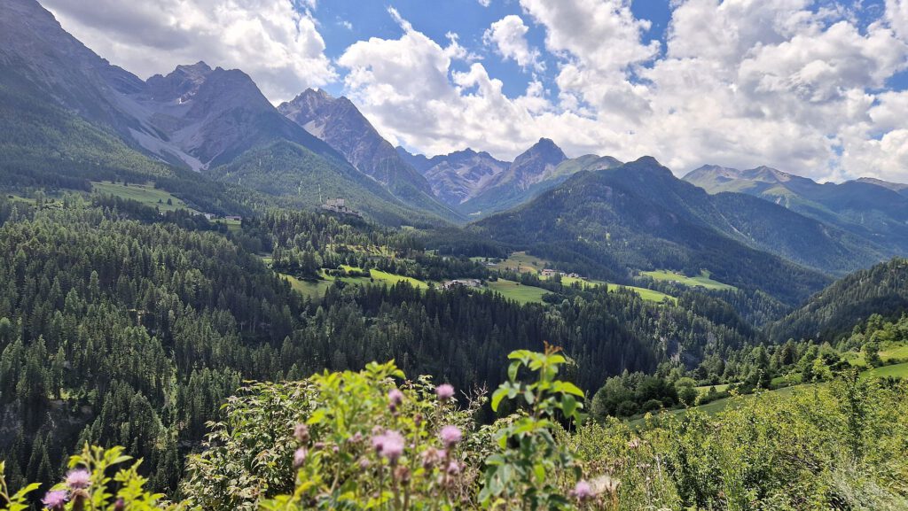 Bergwelt in den Alpen mit Sonnenschein und tief hängenden Wolken